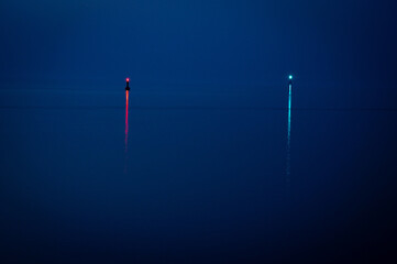 Two illuminated buoys on a calm sea surface at dawn, view of the North Sea or Jade Bay in the morning at the cross-range light, Alte Mole in 26382 Wilhelmshaven, Germany © Frank