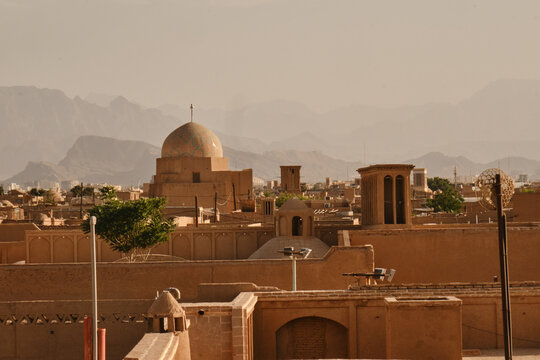 Historic skyline of Yazd old city with mosque dome and mountains in Iran