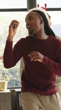 Vertical video: Karaoke track starting, singer in Santa hat singing at home for party, passing mic