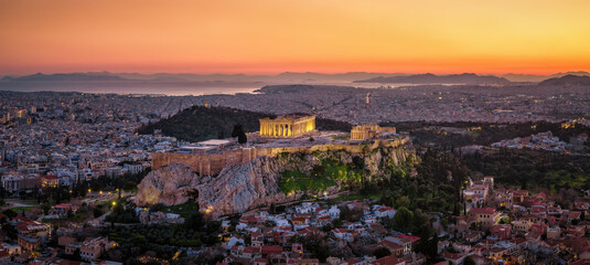 Obraz premium Panoramic aerial view of the illuminated skyline of Athens, Greece, with Parthenon Temple at the Acropolis, old town and seascape during dusk just after sunset