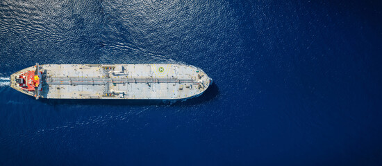Fototapeta na wymiar High aerial top view of a crude super oil tanker traveling over the ocean with copy space as a concept for transport and industry