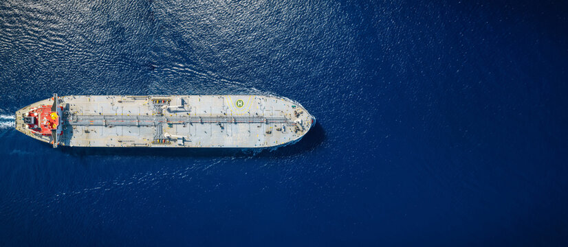 High aerial top view of a crude super oil tanker traveling over the ocean with copy space as a concept for transport and industry