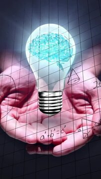 Vertical video: Cupped palms lifting under brain bulb, sparking grid math sketches for education
