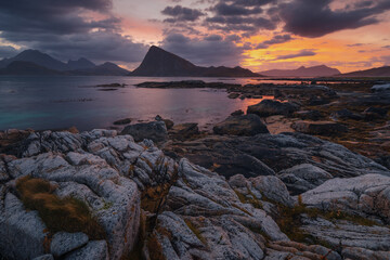 Stunning fall scenery in the Lofoten Islands. Iconic red rorbu cabins nestled between rocky coastlines and dark arctic waters during the golden hour. Travel Norway. © PawelUchorczak