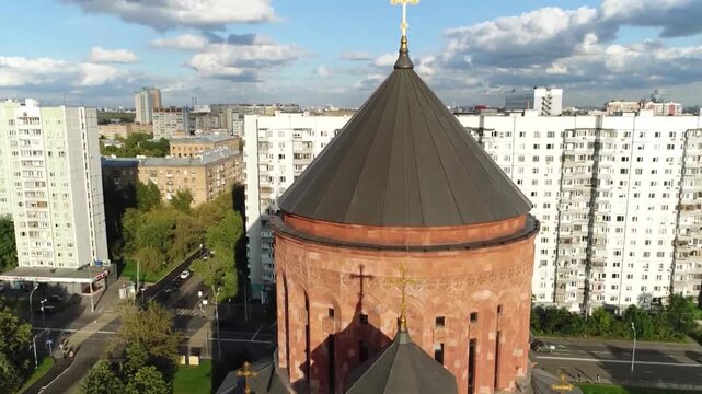 The cross of the Armenian Church towering over the Moscow skyline at sunset