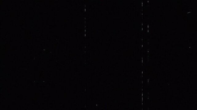 Vintage film dust and scratches overlay on black background cinematic texture. Old film grain dust particles and scratches retro film damage overlay. Cinematic analog film dirt and scratches texture