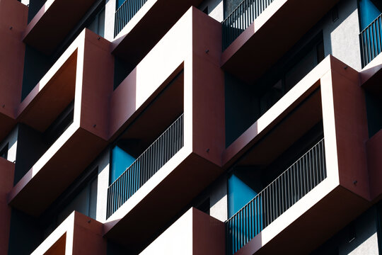 Modern abstract facade studies architecture of a building as balconies and windows cut geometry pattern with hard shadow and strong contrast