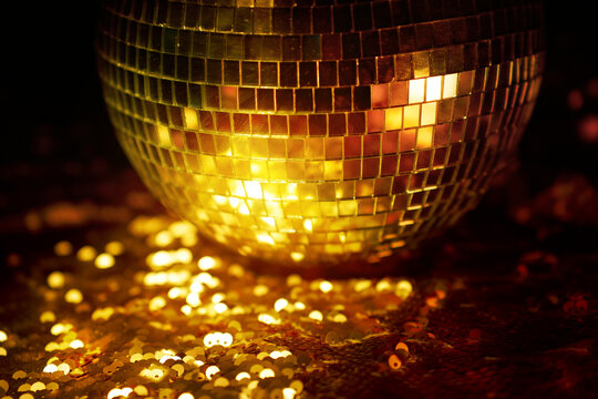 Golden disco ball with glittering light effect at nightclub party