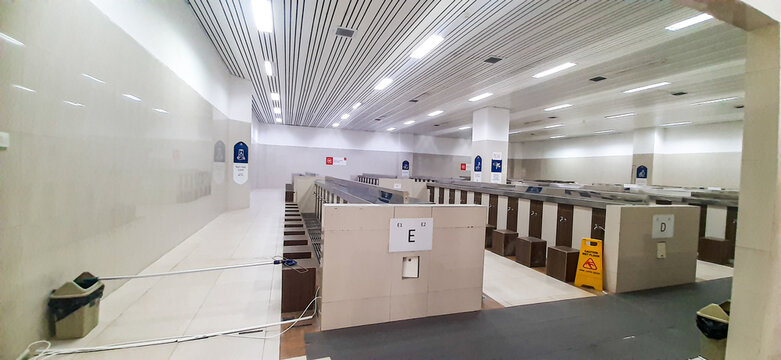 Modern Mosque Ablution Area with Rows of Wudu Stations, Wooden Seats and LED Ceiling Lighting in Clean Islamic Prayer Facility