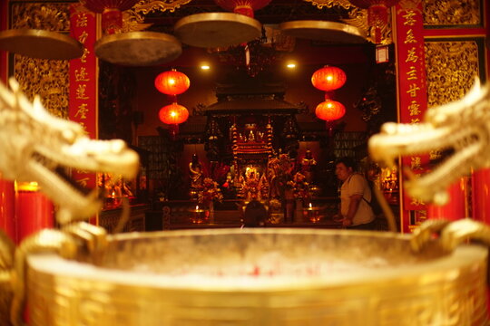 Traditional altar with red lanterns and candles inside Kelenteng Eng An Kiong temple, Malang, East Java.