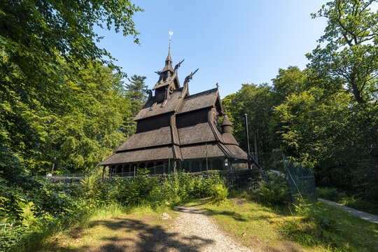 View of the Fantoft Stave Church standing proudly amidst the vibrant green foliage of Bergen's landscape, a testament to Norway's rich heritage, Bergen, Vestland, Norway.
