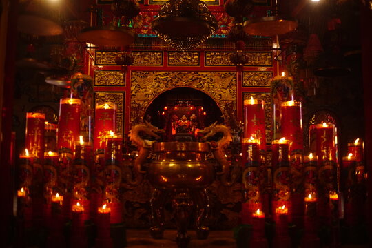 Traditional altar with red lanterns and candles inside Kelenteng Eng An Kiong temple, Malang, East Java.
