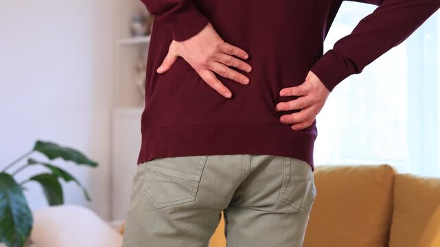 Man with hip, back, spine and sciatica pain at home.	
