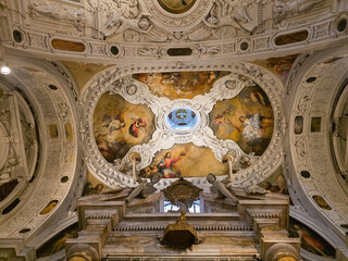 Obraz premium SIENA, ITALY - march 7, 2026: : Low angle view of the ornate Baroque ceiling of San Niccolo in Sasso church, featuring frescoes by Giovan Battista Giustammiani and white stucco decorations