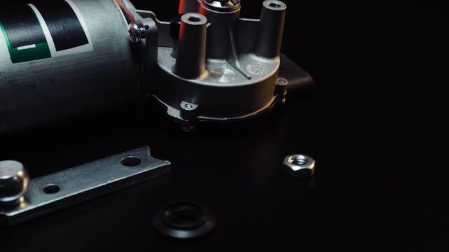 new electric motor for car wipers for windshield cleaning, repair at the service, shooting in a dark room, red light illumination
