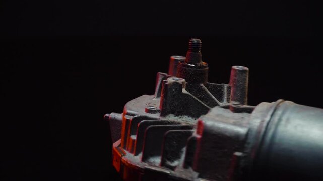old car wiper motor for windshield cleaning, repair at the service, shooting in a dark room, red light illumination