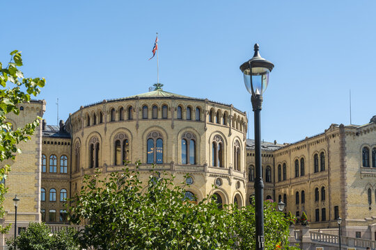 View of the Norwegian Parliament Building, Storting building, with its distinctive yellow facade, under a clear blue sky, Oslo, Oslo, Norway.