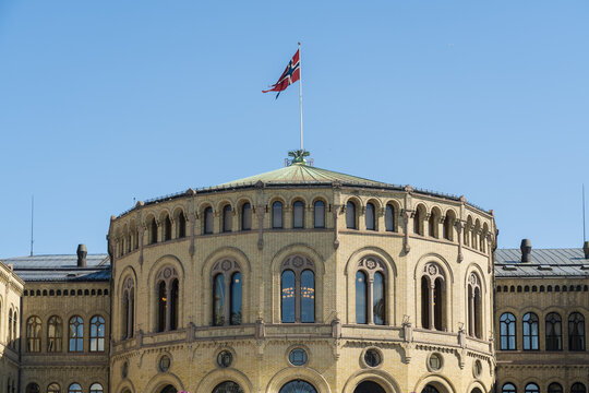 View of the Norwegian Parliament Building, Storting building, with its distinctive yellow facade, under a clear blue sky, Oslo, Oslo, Norway.
