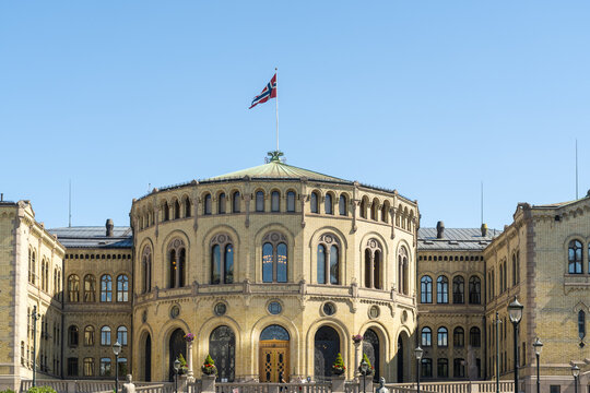 View of the Norwegian Parliament Building, Storting building, with its distinctive yellow facade, under a clear blue sky, Oslo, Oslo, Norway.