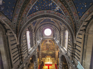 Obraz premium High Angle View of Siena Cathedral Interior from Gate of Heaven (Porte del Cielo), Italy. Majestic Gothic Architecture with Striped Marble Columns, Vaulted Ceiling and Rose Window in Tuscany
