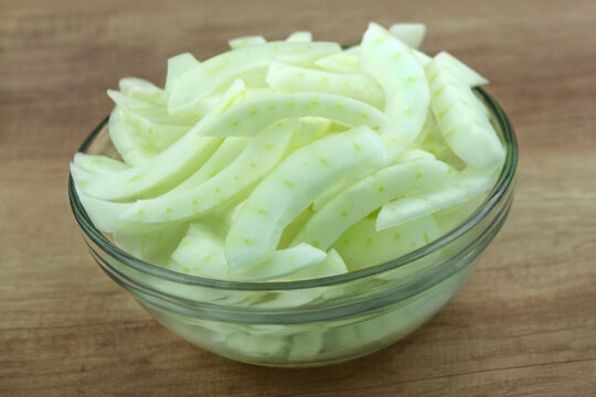 Fresh sliced fennel bulb and glass bowl on wooden background   Fenchel