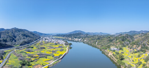 Aerial View of River Valley with Blooming Canola Fields and Mountains © chungking