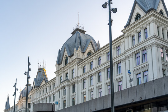 View of the grand, ornate facade of a historic building with elegant windows and a dark roof against a clear sky, showcasing architectural details, Oslo, Oslo, Norway.