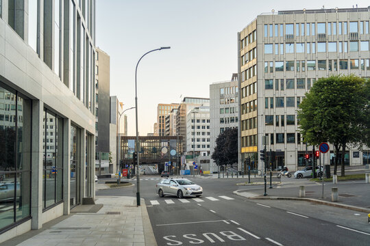 View of sleek, modern architecture casts long shadows across the quiet streets as a lone car glides through the city, Oslo, Oslo, Norway.