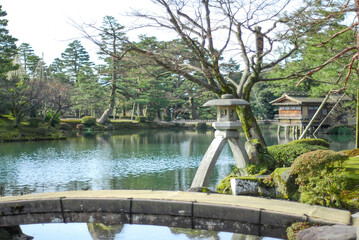 兼六園・霞ヶ池の冬日和：薦掛けの虹橋とことじ灯籠が織りなす静謐な風景 / Winter Day at Kasumigaike Pond in Kenrokuen: A Serene Scene of Niji-bashi Bridge with Komogake and Kotoji-toro Lantern