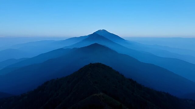 Abstract mountain range silhouette against a blue sky and atmospheric haze