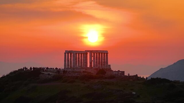 Establishing aerial view of the ancient Temple of Poseidon at Cape Sounion, Attica, Greece, during a colorful sunset