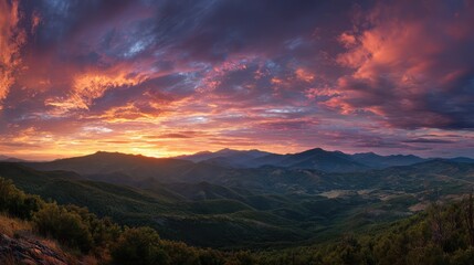 Fototapeta premium Panoramic mountain range stretching across horizon with dramatic sunset sky
