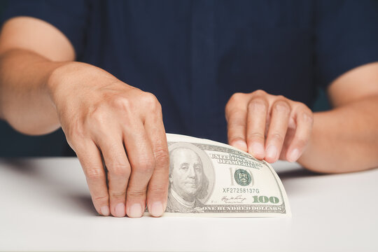 Hand putting dollar banknote on table saving money concept.