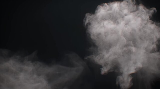 Wisps of white vapor curl and dance against a dark backdrop, creating an ethereal atmosphere