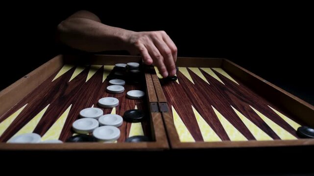 Close-up of Hands Setting Up Initial Pieces on a Backgammon Board, Preparing for the Game