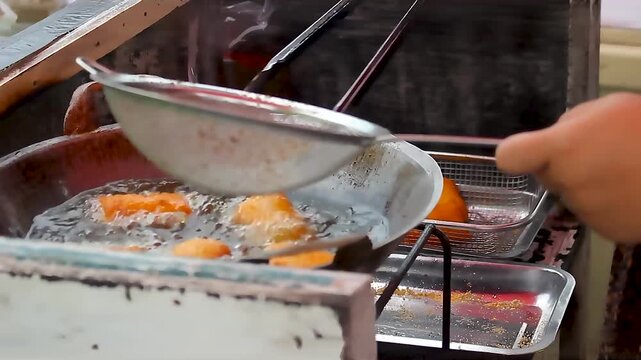 draining food that has been fried in hot oil in a frying pan 