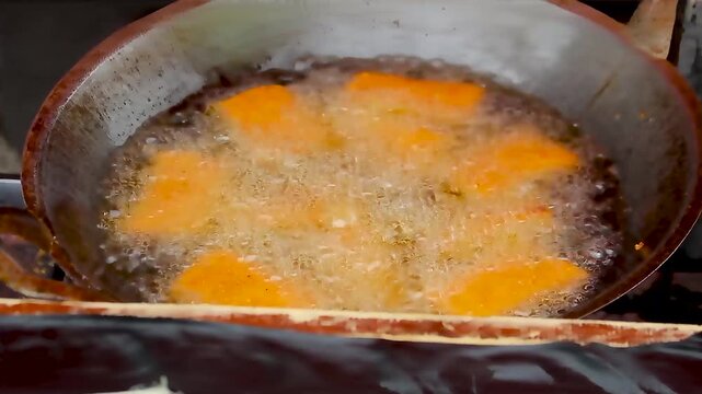 street food being fried in a pan and hot oil 