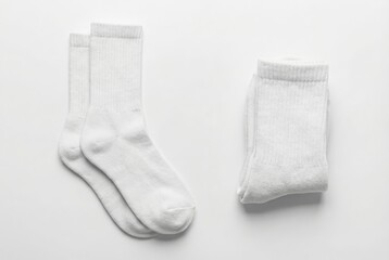 Pair of white crew socks laid out and folded on a white background
