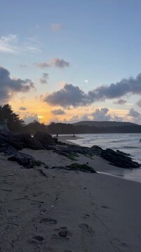 Cinematic view of ocean waves and scenic coastline at Samila Beach during sunset in Songkhla, Thailand.
