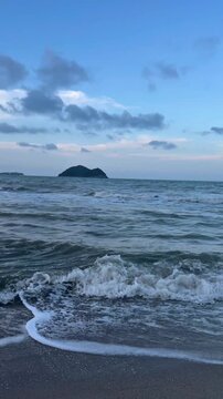Cinematic view of ocean waves and scenic coastline at Samila Beach during sunset in Songkhla, Thailand.