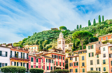 Fototapeta premium beautiful landscape of famous italiat resort Portofino in Luguria with ancient houses and buildings of hotels and restaulants along the embarkment of a sea gulf with sunset golden light
