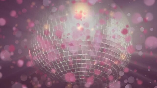 Animation of pink ight spots falling over spinning golden disco ball on grey background