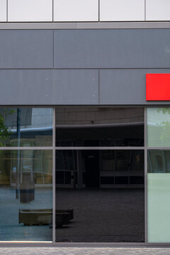 Modern minimal urban storefront facade with glass entrance and clear reflection on exterior architecture creating clean commercial frontage