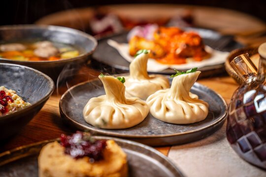 Steaming khinkali dumplings served on rustic restaurant table