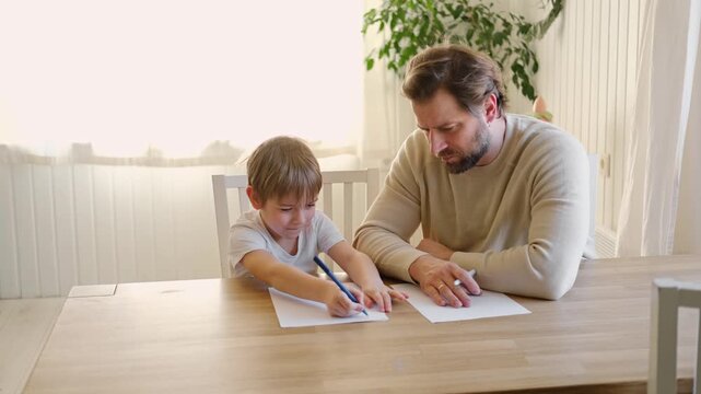 Dad teaches his son writing and counting. Kids primary education. Children learn, study in home school. Daddy male helping teaching little child boy support studying, learning homework. Knowledge day.