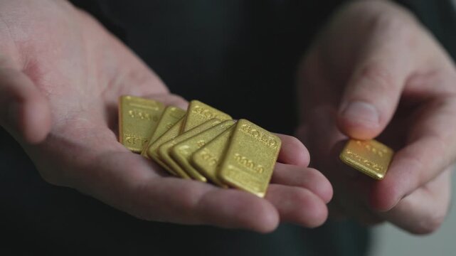  Close-Up of Man Holding Gold Bars in Hand