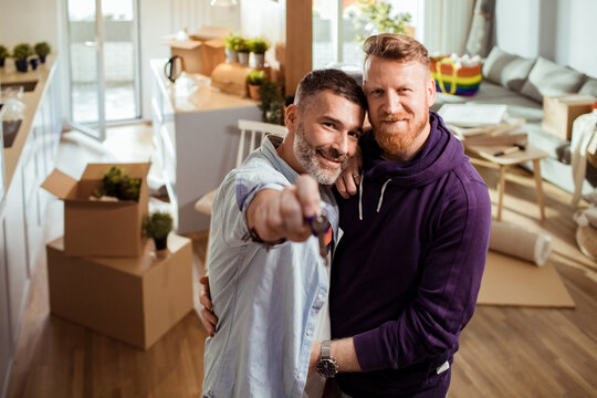 Happy couple holding house keys in new apartment