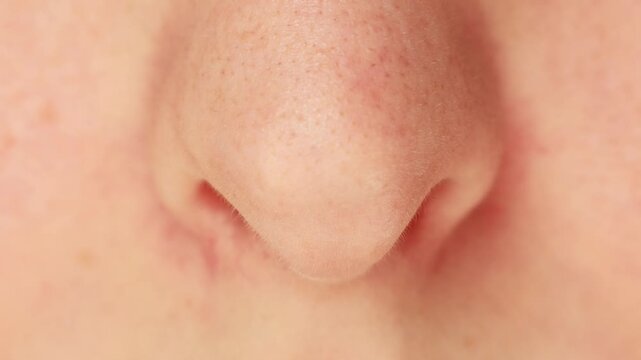 Female nose moving while breathing with skin structure close up