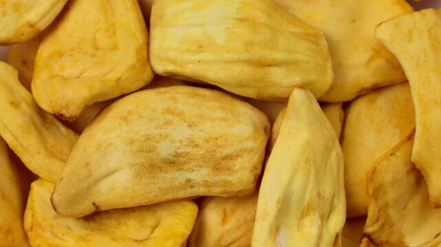 Yellow dried jackfruit slices circle rotation close up