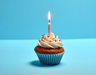 Single cupcake with frosting, sprinkles, and a lit candle against a light blue backdrop